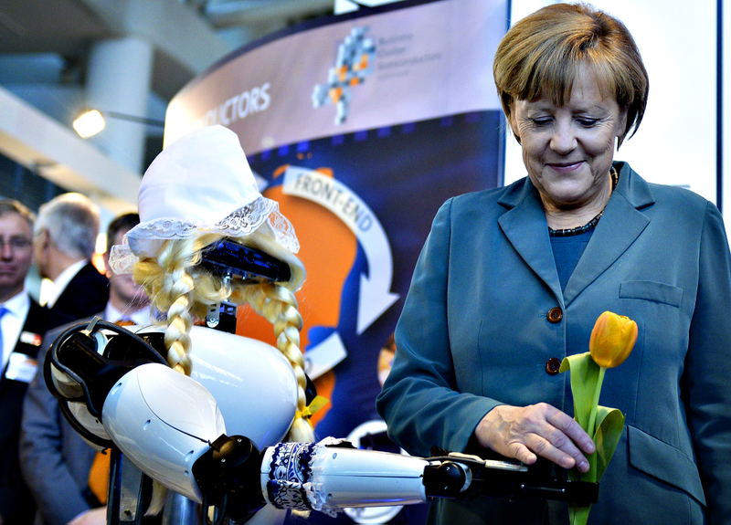 Illustration for article titled Why Is Angela Merkel Always Palling Around With Robots?